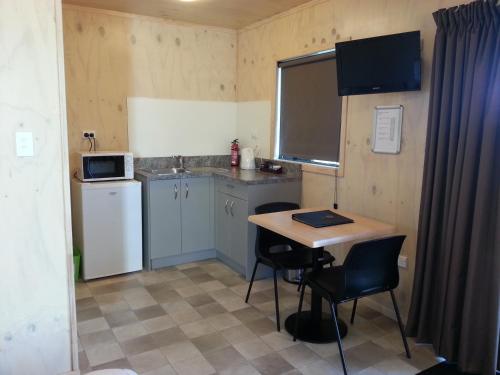 a small kitchen with a small table and a sink at Martinborough TOP 10 Holiday Park in Martinborough 