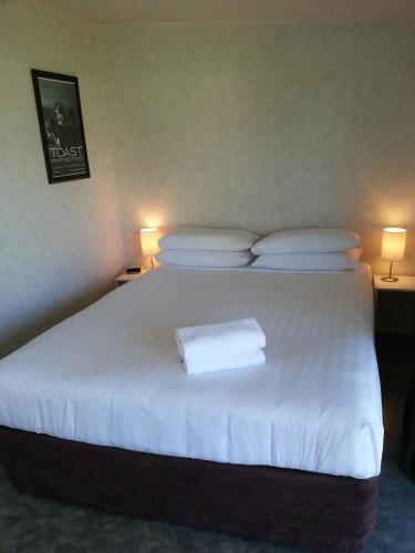 a bedroom with a large bed with white sheets and pillows at Martinborough TOP 10 Holiday Park in Martinborough 