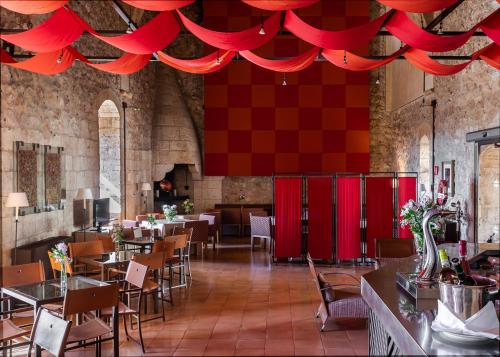 a restaurant with red curtains and tables and chairs at Parador de Alarcón in Alarcón