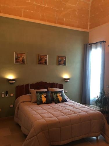 a bedroom with a large bed and a window at Signorino Suites&Pool in Marsala