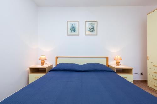 una camera con letto blu e due comodini di Apartment Marija a Mali Lošinj (Lussinpiccolo)
