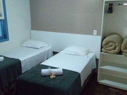 Zimmer mit 2 Betten und einem Handtuch auf dem Tisch in der Unterkunft Casa da Vó Nelsi in Gramado