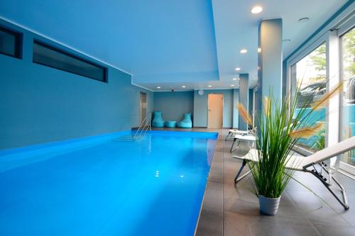 a swimming pool with blue lighting in a building at Parkhotel Residenz in Sankt Peter-Ording