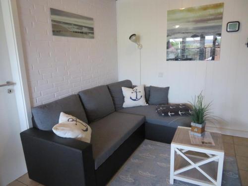 a living room with a couch and a table at Ferienhäuser Seemannsgarn in Friedrichskoog-Spitz