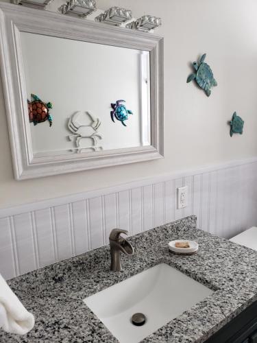 a bathroom with a sink and a mirror at Ashley Brooke Beach Resort in Deerfield Beach