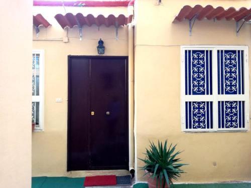 a house with a black door and two windows at Vomero House with Free Parking 410 cm in Naples
