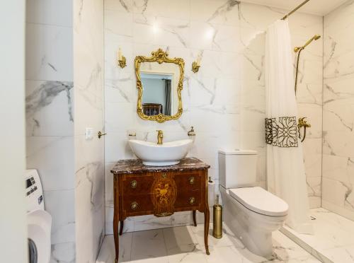 un bagno con lavandino, WC e specchio di Nostalgia Apartment a Klaipėda