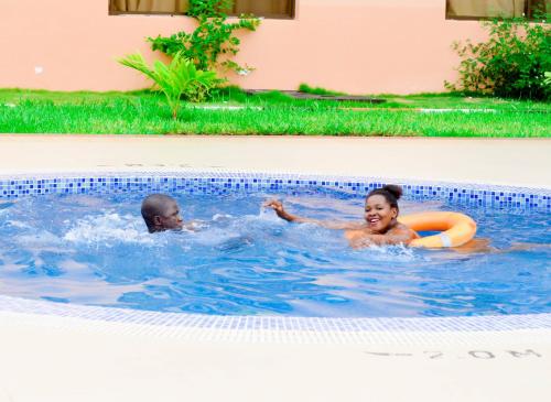 two people swimming in a swimming pool at Luwa Evergreen Hotel in Mtwara
