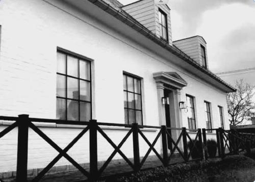 une photo en noir et blanc d'une maison avec une clôture dans l'établissement L'Oisette, à Ghislenghien