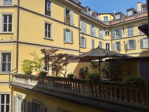 un ombrellone su un balcone di fronte a un edificio di Green Tricolore a Milano