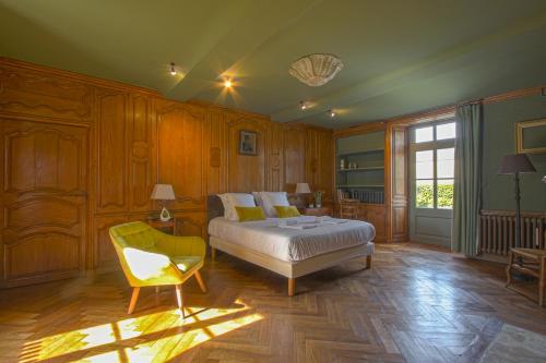 バイユーにあるChâteau de Monceaux 5mn de Bayeux proche Merのベッドルーム1室(ベッド1台、椅子付)