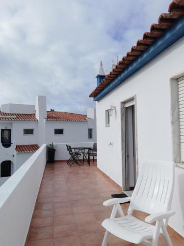a balcony with two white chairs on a white building at Casa Furt@do in Burgau
