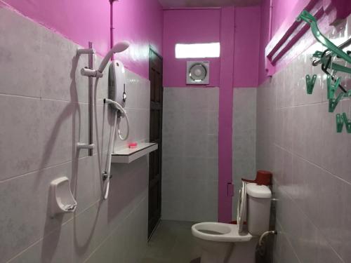 a bathroom with a toilet and a shower with purple walls at Standard Room (Pakej G1) in Semporna