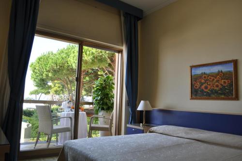 a bedroom with a bed and a window at Grand Hotel La Playa in Sperlonga