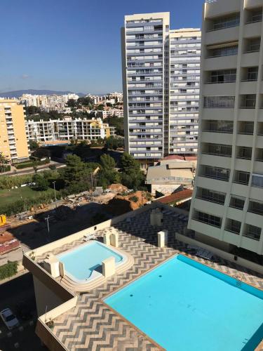 a swimming pool on top of a building with tall buildings at Acropole Algarve Beach Apartment in Portimão
