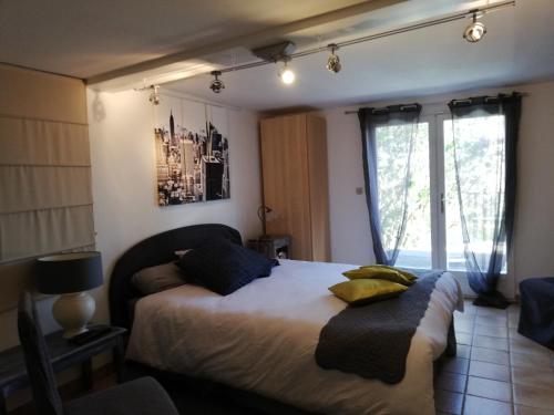 een slaapkamer met een bed met 2 kussens erop bij La Fargette in Saint-Fargeau-Ponthierry
