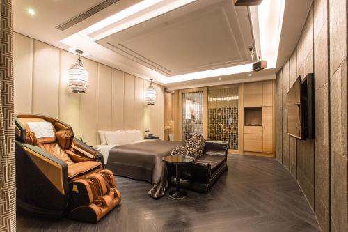 a hotel room with a bed and a couch and chair at Feng Cai Motel in Yuanlin