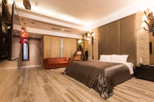 a hotel room with a bed and a chair at Feng Cai Motel in Yuanlin