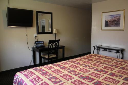 una camera d'albergo con letto, scrivania e TV di Lava Spa Motel & RV a Lava Hot Springs