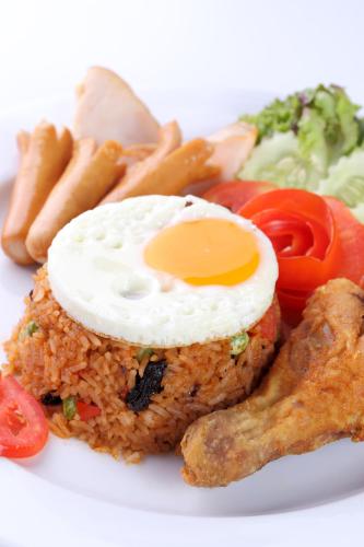 een bord voedsel met een ei op de rijst bij PJ Watergate Hotel in Bangkok