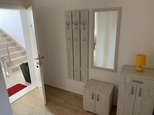 a bathroom with a mirror and a wooden cabinet at Airport view Apartment in Belgrade