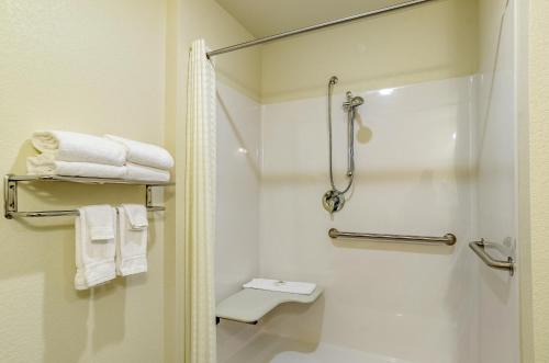 a bathroom with a shower and a toilet and towels at Cobblestone Inn & Suites - Bridgeport in Bridgeport
