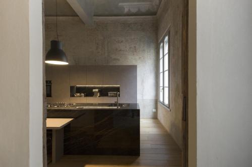 a kitchen with a black island in a room at Appartamento affrescato 180mq in palazzo del 600 a Mantova in Mantova