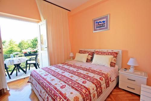 a bedroom with a bed and a balcony with a table at 2 Bedrooms Apartment Margarita 4+2 in Supetar
