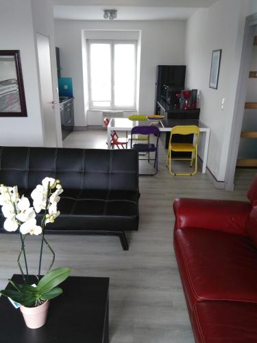 un salon avec un canapé noir et une table dans l'établissement Appartement Vue Mer, à Crozon