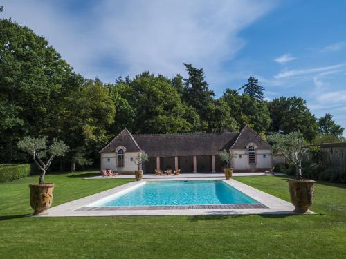 une maison avec une piscine dans une cour dans l'établissement La commanderie aux portes de Chambord, à Huisseau-sur-Cosson