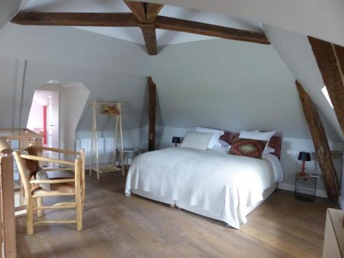 une chambre avec un lit blanc et une chaise dans l'établissement La commanderie aux portes de Chambord, à Huisseau-sur-Cosson