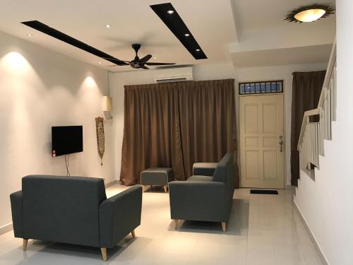 - un salon avec deux chaises et une télévision dans l'établissement NZAK Homestay, Bukit Bandaraya Seksyen U11, à Setia Alam