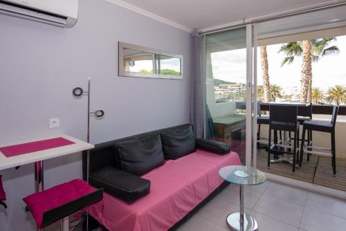 a living room with a pink couch and a table at Port Nature Village Naturiste in Cap d'Agde