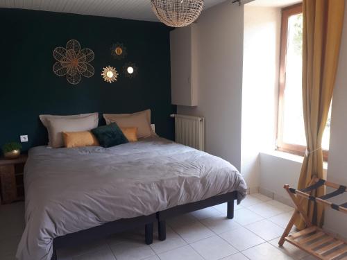 1 dormitorio con 1 cama grande y pared verde en Un Beau Regard sur la nature !, en Mauléon
