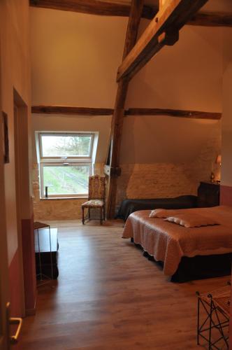 a bedroom with a bed and a window in a room at Les Pierres D'aurèle Chambres d'Hôtes in Saint-Georges-sur-Cher