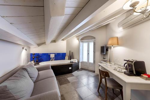 ein Wohnzimmer mit einem Sofa, einem Tisch und einer Badewanne in der Unterkunft Locanda Don Serafino Historical Boutique Hotel in Ragusa