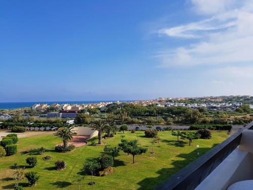 a view of a park with palm trees and the ocean at CapSexy Port Nature Waiki Naturist Village in Cap d'Agde