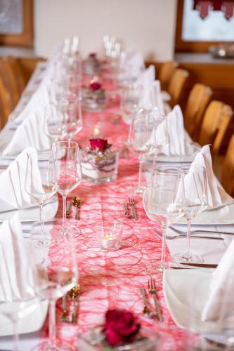a long table with wine glasses and napkins at Hotel-Restaurant Straussen in Harburg