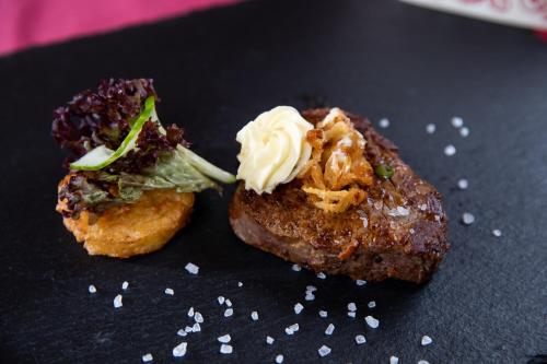 two pieces of food sitting on a black plate at Hotel-Restaurant Straussen in Harburg