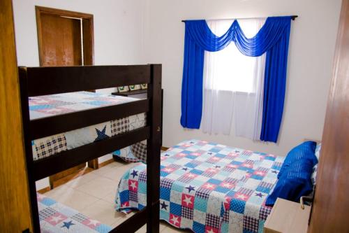 a bedroom with two bunk beds and a window at Pousada Nascimentos in Bertioga