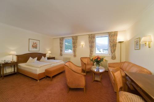 a hotel room with a bed and a table and chairs at Vergeiner's Hotel Traube in Lienz