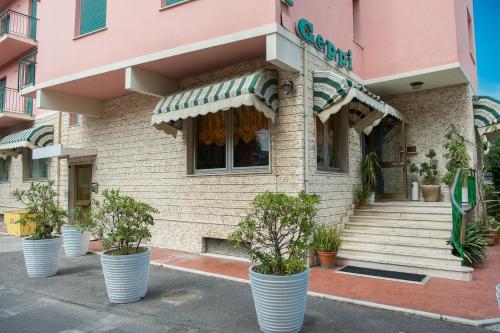 a store front with potted plants in front of it at Hotel Geppi in Pietra Ligure