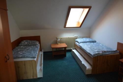 two beds in a small room with a window at Nerudova SIX in Košice