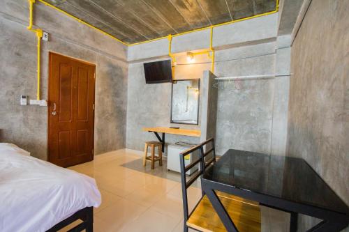 a bedroom with a bed and a desk in a room at The Sky Loft Hotel in Pathum Thani