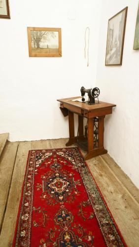 a room with a wooden table and a red rug at Schloss Berg Klösterle in Zedlitzdorf