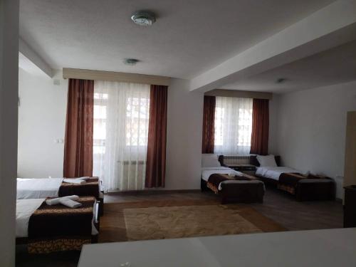 a room with two beds and a couch and windows at Apartmani Ambiente in Plav