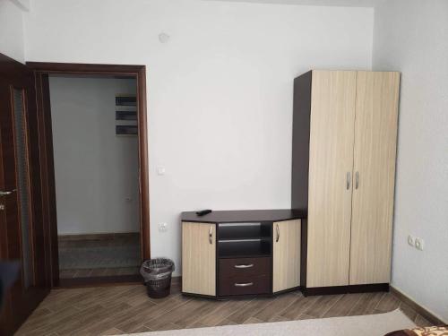 a room with a tv and a wooden cabinet at Apartmani Ambiente in Plav