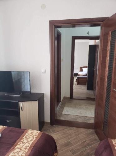 a bedroom with a mirror and a bed and a television at Apartmani Ambiente in Plav