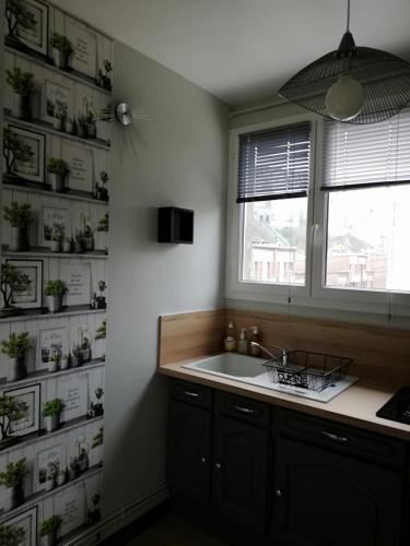 une salle de bain avec un lavabo et une fenêtre dans l'établissement L'ENTRE 2 COTES, au Tréport