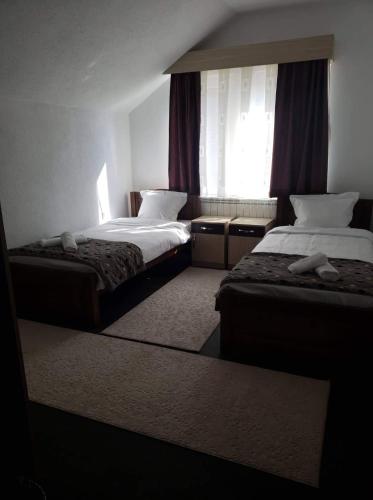 a hotel room with two beds and a window at Apartmani Ambiente in Plav
